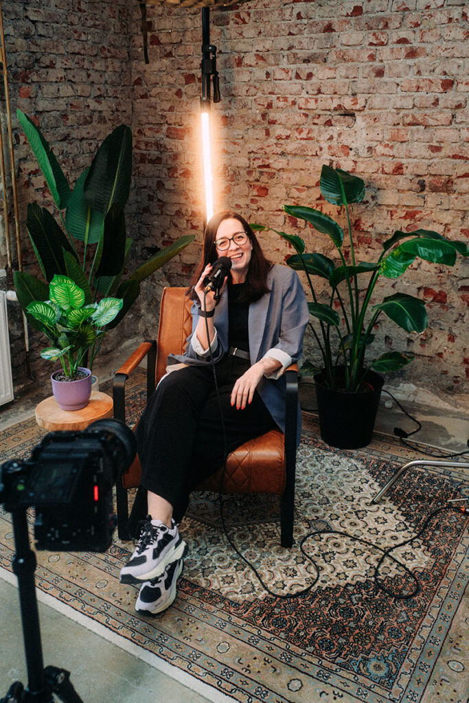 Tamai Bruns im Podcast Setting mit Mikrofon